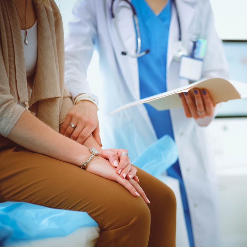 Doctor and patient discussing something while sitting at the table . Medicine and health care concept. Doctor and patient