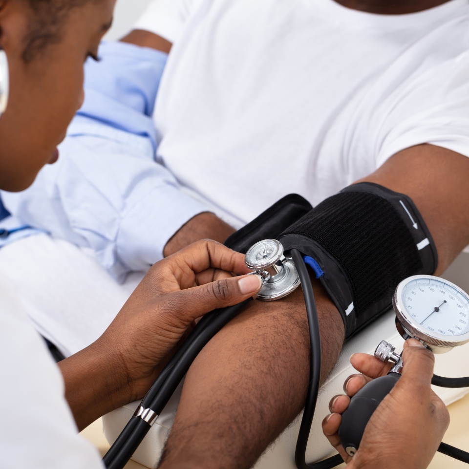 Close-up Of Doctor's Hand Measuring Blood Pressure Of Male Patient