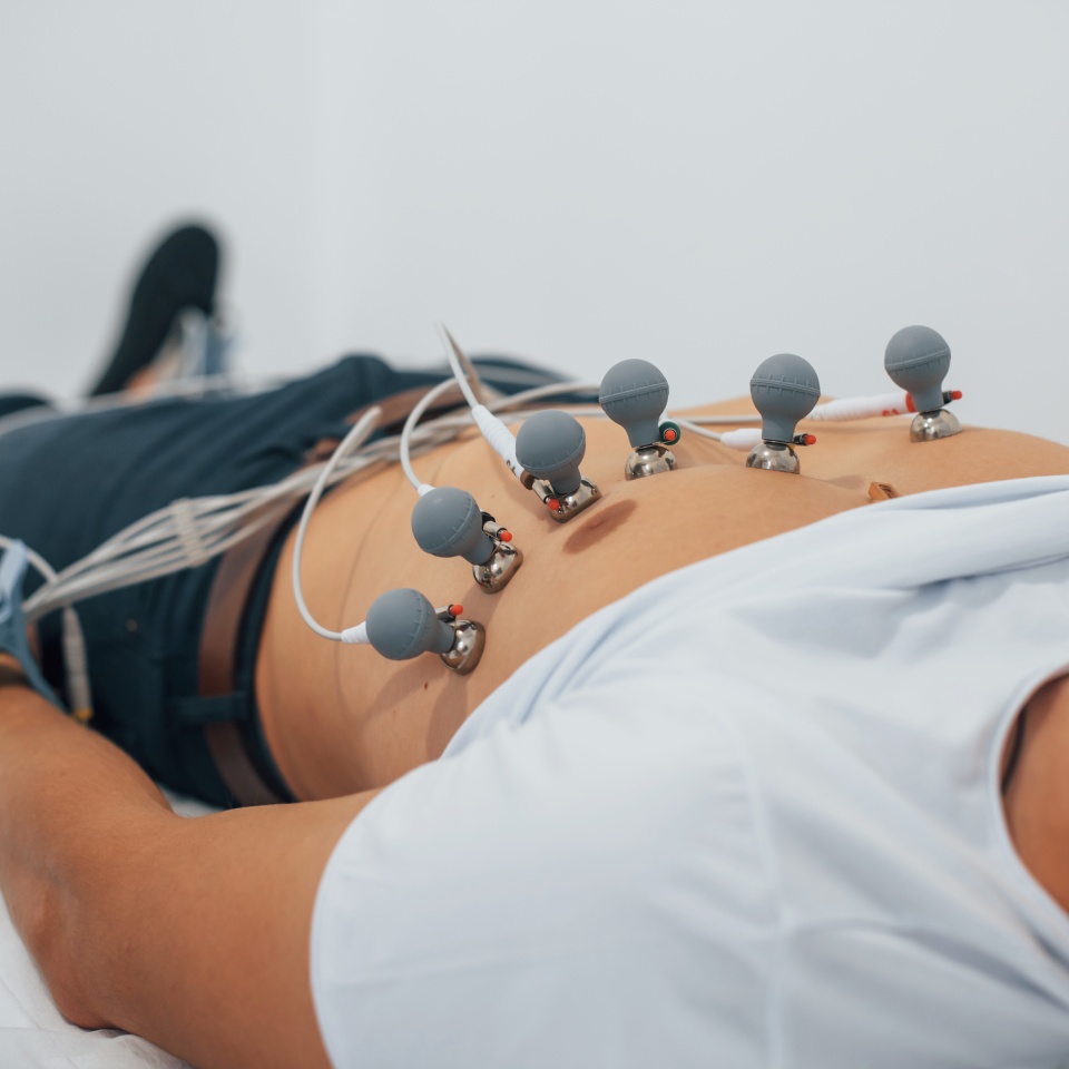 Man lying on the bed in the clinic and getting electrocardiogram test.