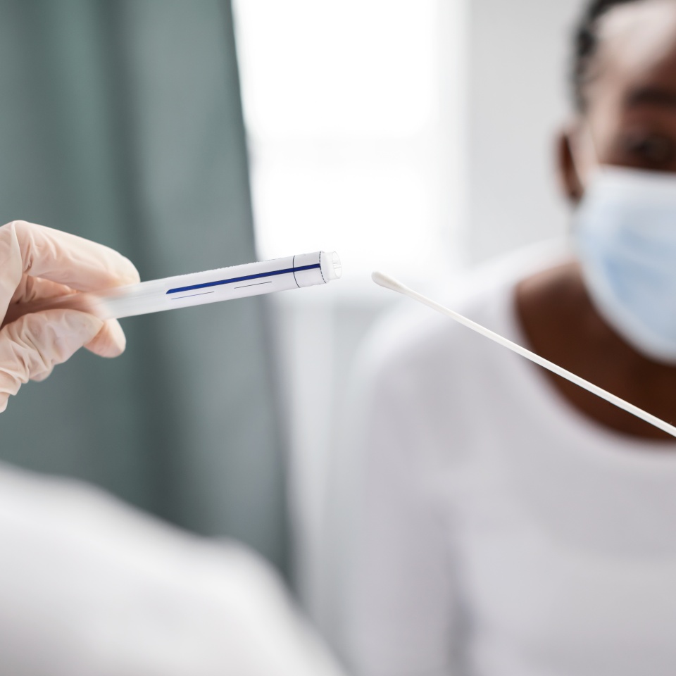 Doctor taking PCR test sample from potentially infected afro woman