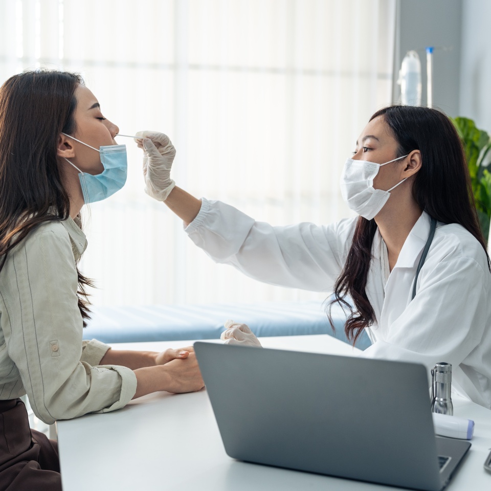 Asian professional specialist doctor diagnosis PCR Coronavirus sample. Young female physician use a rapid antigen test doing quick swab for patient during Covid pandemic in medical laboratory hospital