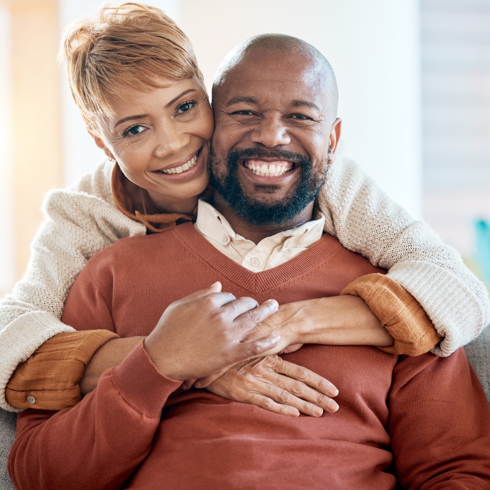 Happy, love and portrait of black couple on sofa for relax, retirement or support together. Smile, hug or marriage with old man and woman in living room at home for bonding, relationship or lifestyle
