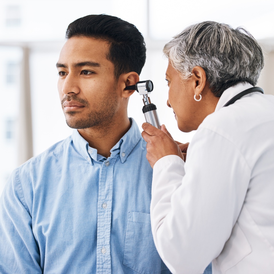 Doctor check patient ear, consultation and healthcare, people at hospital with otolaryngology specialist. Man and senior physician woman with otoscope test for hearing problem and health insurance
