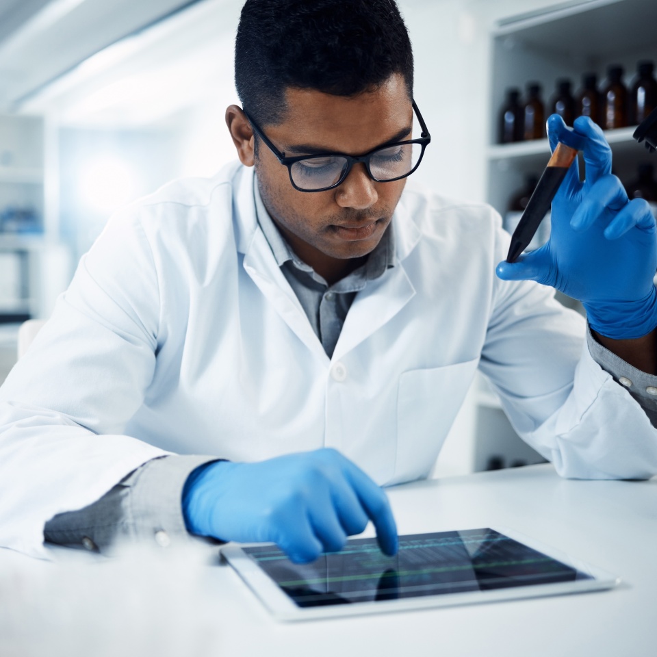 Science, blood sample and man on tablet in laboratory for medical analysis, research and online report. Healthcare, pharmaceutical and male scientist on digital tech for medicine, dna or test results