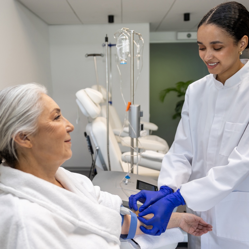 Doctor doing IV infusion for senior woman patient in beauty clinic.
