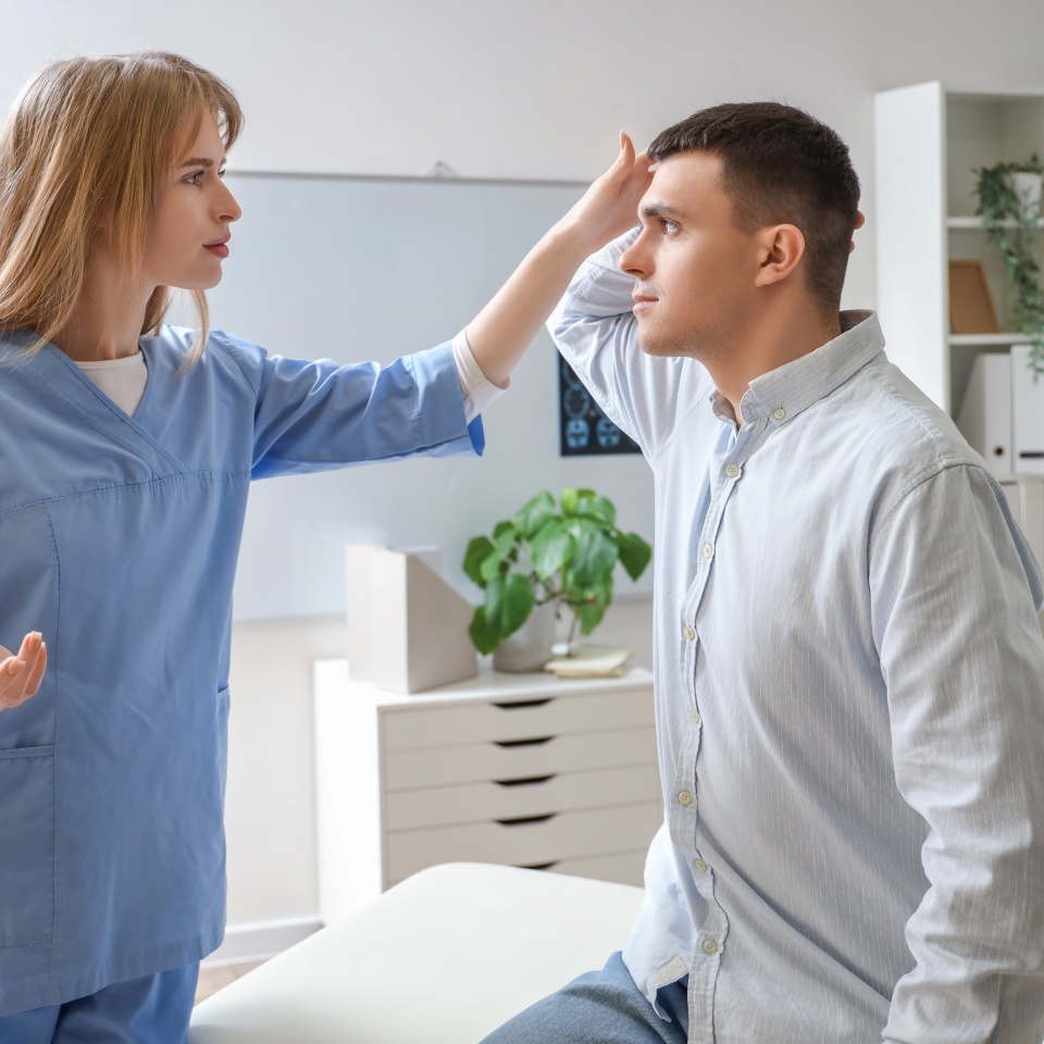 Young man with brain concussion visiting doctor in clinic