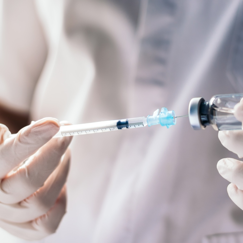 injecting injection vaccine vaccination medicine against covid-19 into a syringe. Close-up