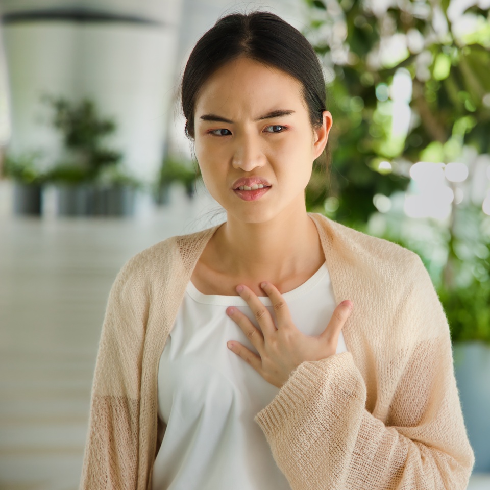 ill Asian woman with acid reflux or gerd symptoms, acidic esophageal, heartburn sickness