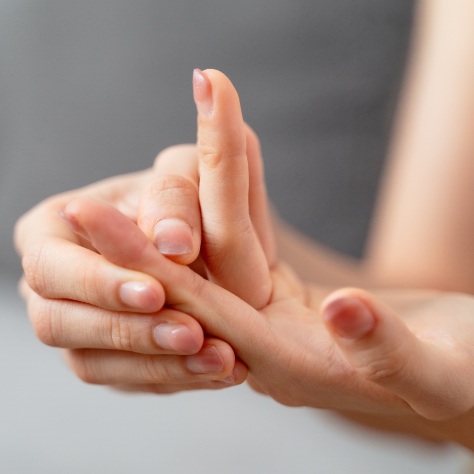 Closeup young woman sitting on sofa holds her wrist. hand injury, feeling pain. Health care and medical concept.
