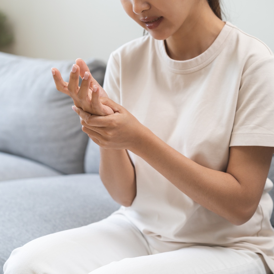 Health care and medical concept, rheumatism asian woman hand pain from cramp, trigger finger, wrist pain touching massaging, hand holding ache joint, arthritis inflammation.Chronic disease from injury
