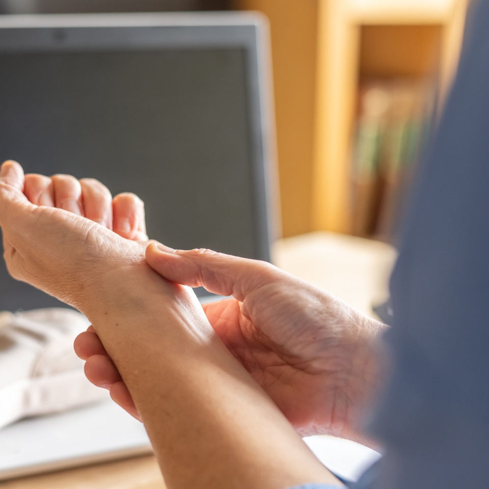 Person Suffering From Wrist Pain Due To Repetitive Computer Work, Highlighting Carpal Tunnel Syndrome And Tendonitis, Working From Home Office With Hand Strain While Typing On Keyboard