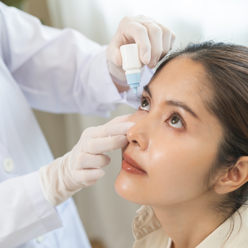 Health care concept, eye doctor eye drops to asian young woman patient, hand using medical eye drop to treat dry eye, suffering irritation or inflammation, allergy optical symptom at optic clinic.