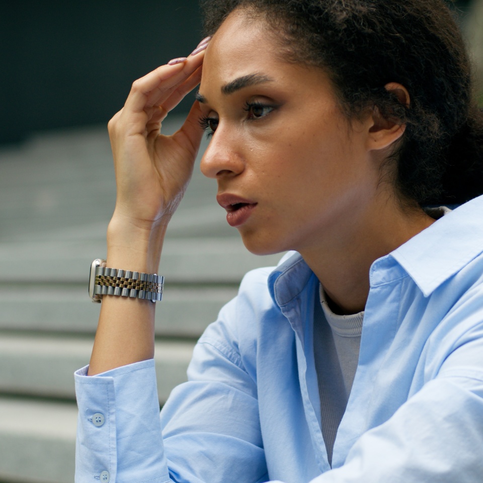 Tired exhausted fatigued African American woman female waiting meeting sad disappointed lady girl business businesswoman in city sitting stairs stairway suffer stress looking at wrist watch check time