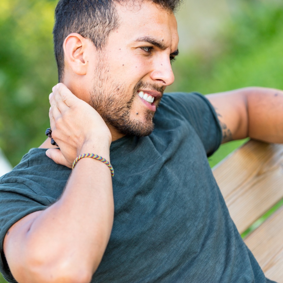 young man outdoors scratching because of an insect bite
