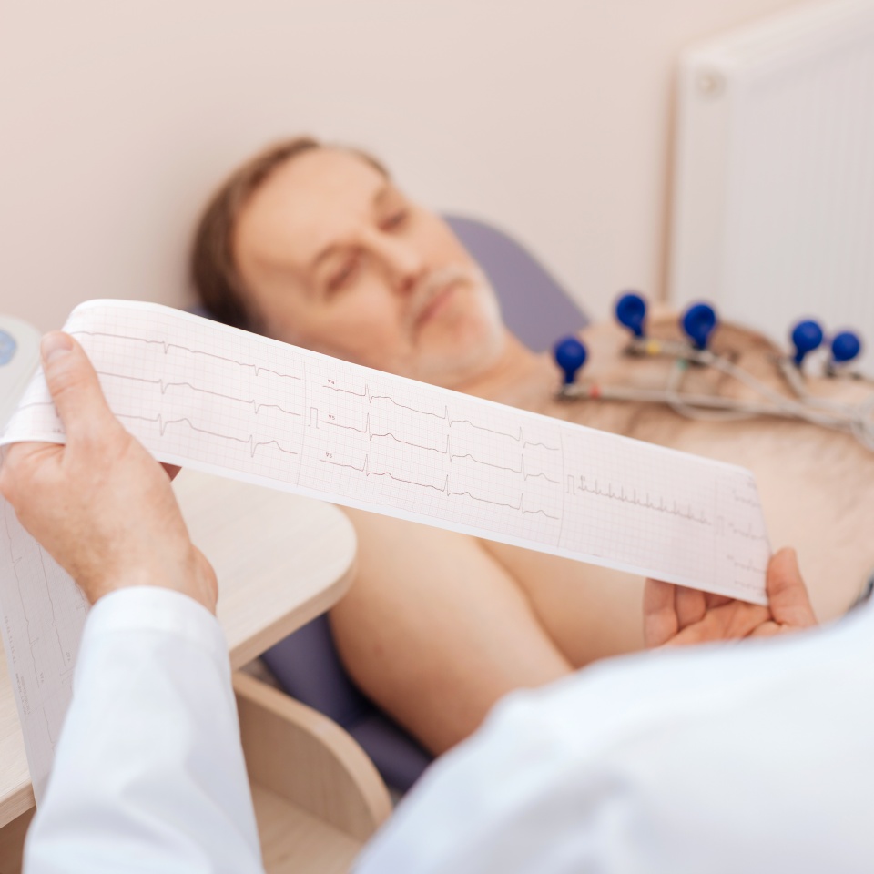 Excellent trained cardiologist carefully studying patients cardiogram