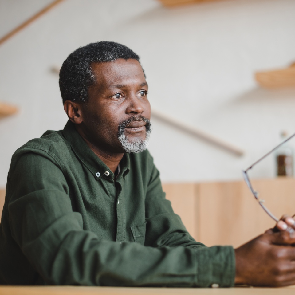 thoughtful mature african american man sitting in cafe
