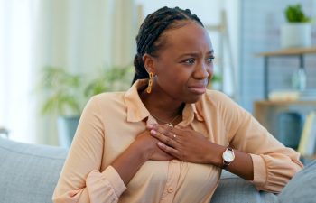 Black woman, chest pain and heart with health issue at home, emergency and breathing fail with indigestion. Respiratory, pneumonia or tuberculosis, lungs or cardiovascular healthcare or anxiety