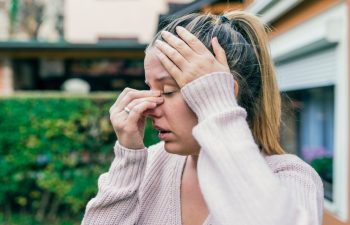 Sinus ache causing very paintful headache. Unhealthy woman in pain. Sharp strong sore. Sinus pain, sinus pressure, sinusitis. Sad woman holding her nose and head because sinus pain